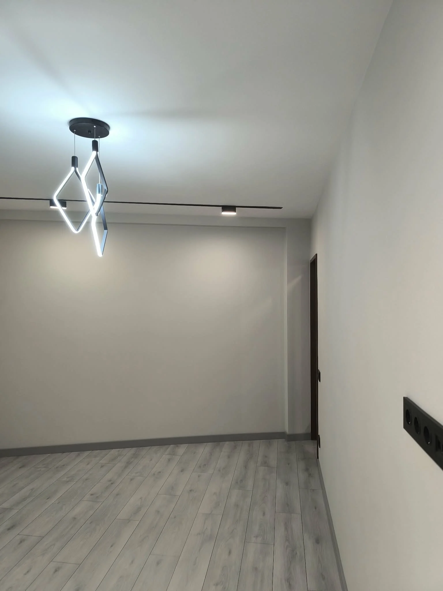 Contemporary room with geometric pendant and track lighting