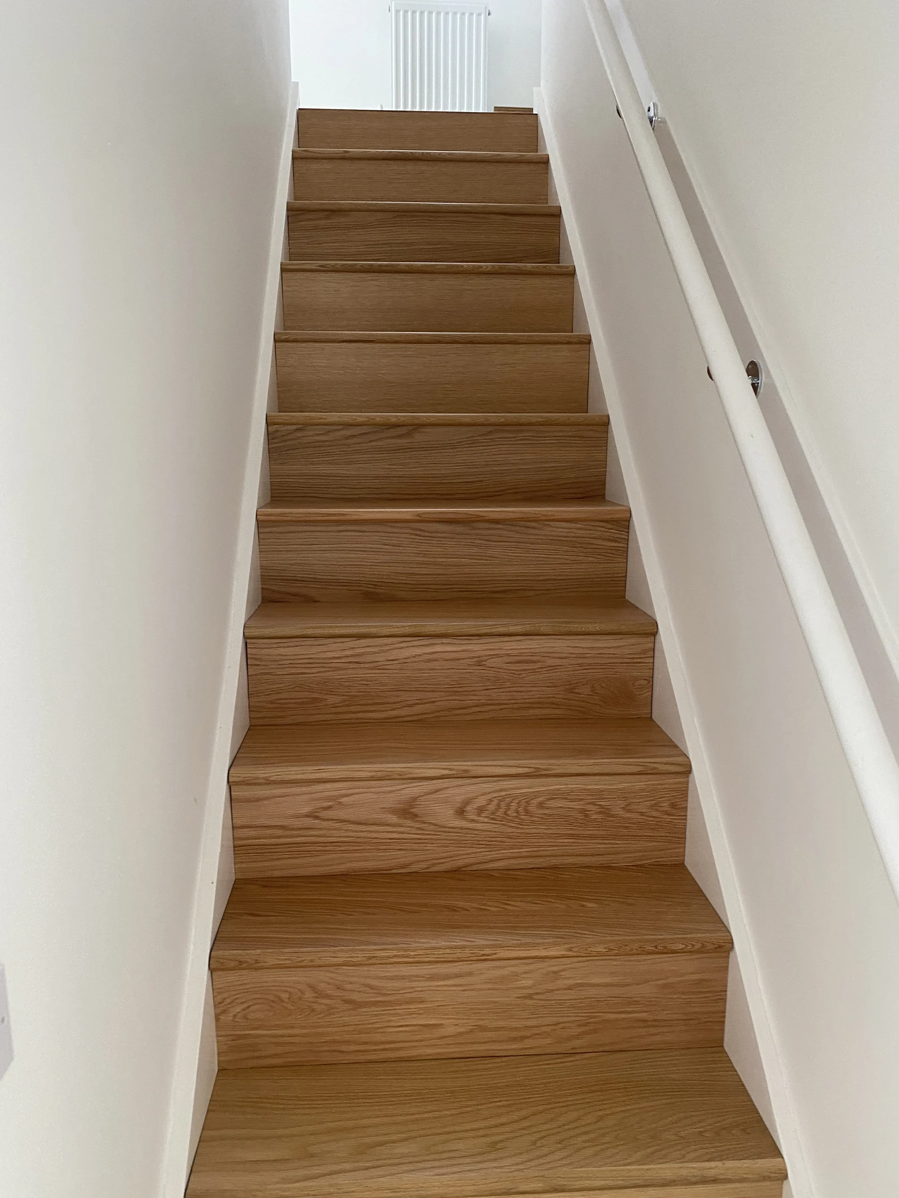 Finished natural timber staircase with white walls