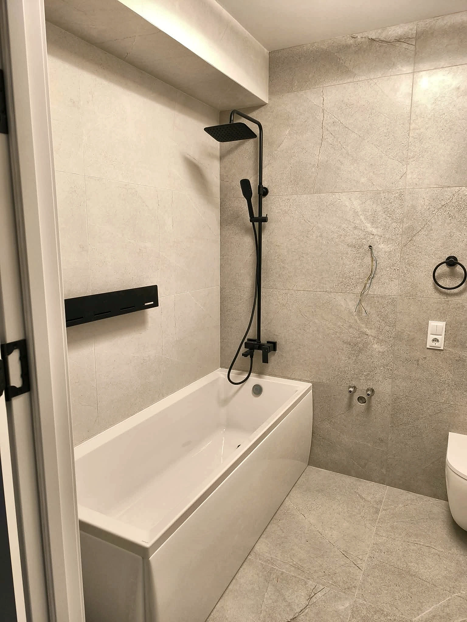 Finished bathroom with coordinated grey tiles
