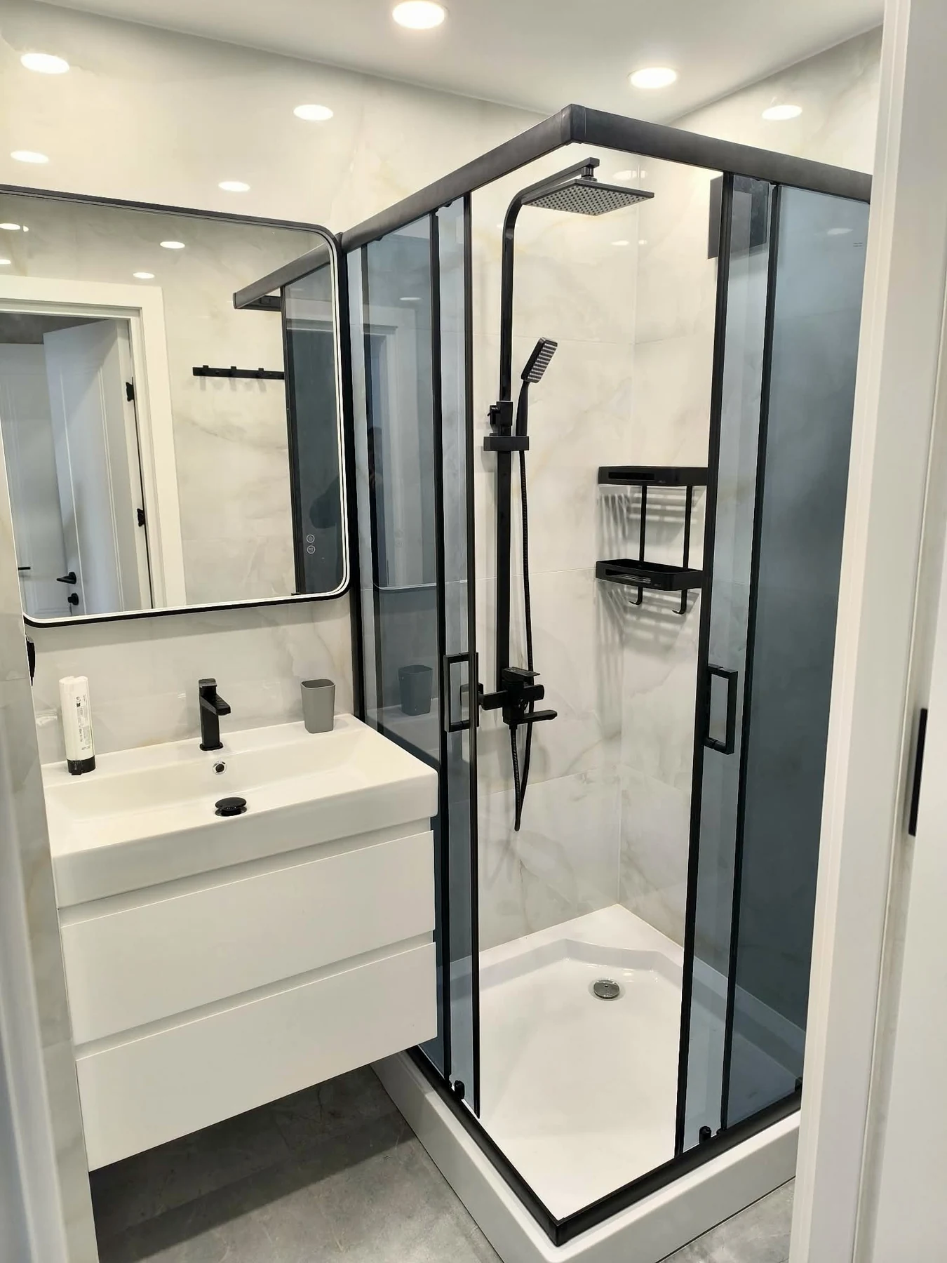 Black-framed shower enclosure in a tiled bathroom